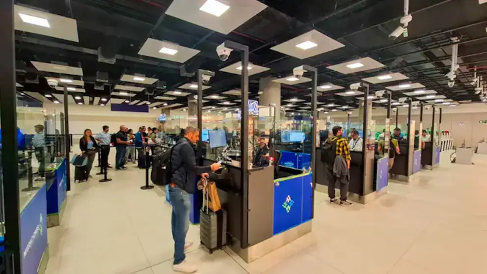 Pasaportes y control migratorio en el aeropuerto de Loreto, mostrando a viajeros en proceso de check-in y seguridad.