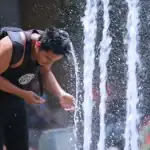 Refrescándose en fuente urbana en Loreto Noticias, imagen de un joven en verano.