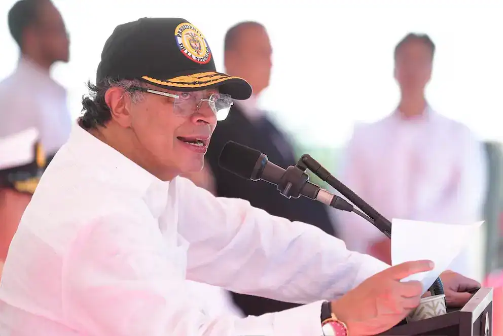 Joven político con gorra de Loreto Noticias hablando en conferencia de prensa en un evento oficial en Loreto, Perú, durante el día.