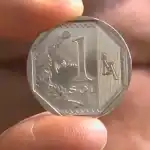 1. imagen de una moneda de 1 sol peruano sendo mostrada por una mano, fondo de piel, detalles visibles del diseño y tamaño de la moneda, cultura e historia peruana.