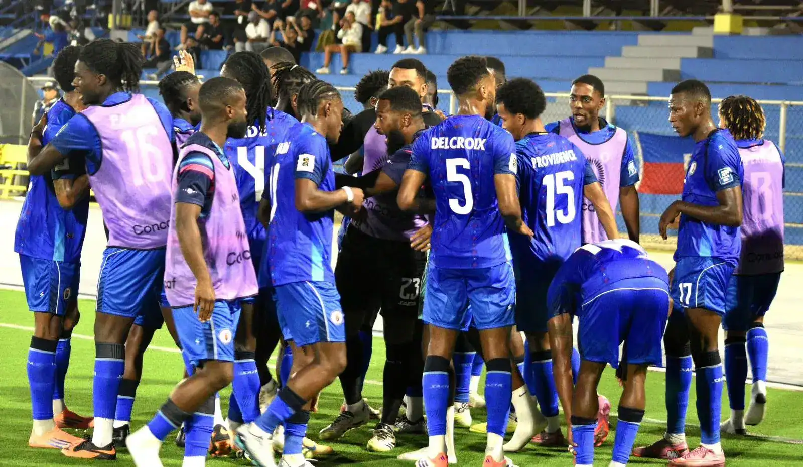 Jugadores de fútbol profesional en el campo durante un partido en Loreto, Perú, mostrando el apoyo y trabajo en equipo en un escenario deportivo.